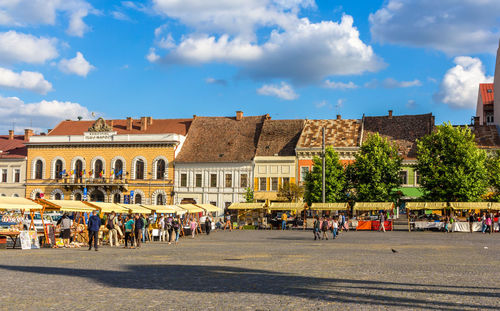 People on street against buildings in city