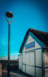 Low angle view of street light against blue sky