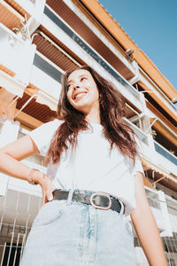 Young woman standing against building