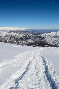 Scenic view of snowcapped mountains against clear blue sky