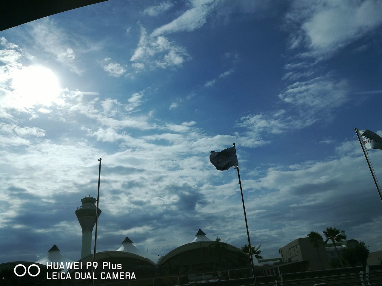 low angle view, sky, architecture, built structure, street light, cloud - sky, lighting equipment, city, cloud, cloudy, road sign, outdoors, day, no people, information sign, blue, travel destinations, city life, pole, information, high section, illuminated