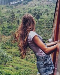 Woman peeking from train against mountain