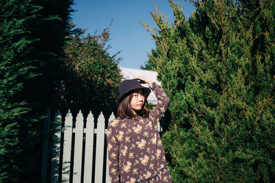 Portrait of woman standing by tree
