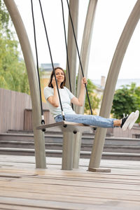Full length of woman sitting on swing