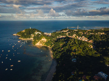 High angle view of city by sea against sky