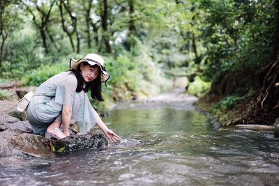 Portrait of woman by river in forest