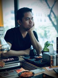 Portrait of young man sitting at table