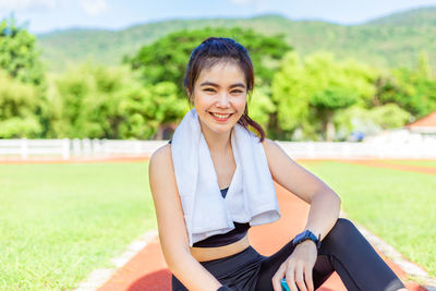 Portrait of smiling young woman sitting outdoors