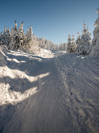 Snow covered landscape against clear sky