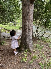 Rear view of girl on tree trunk