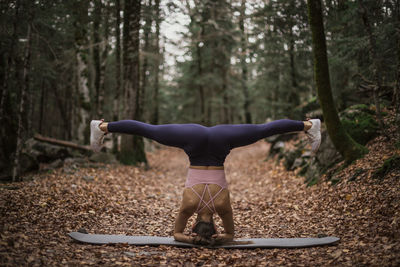 Full length of woman with arms raised in forest