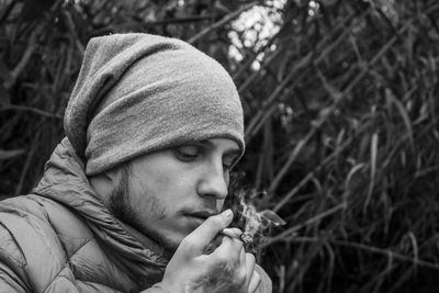 Man smoking marijuna against plants