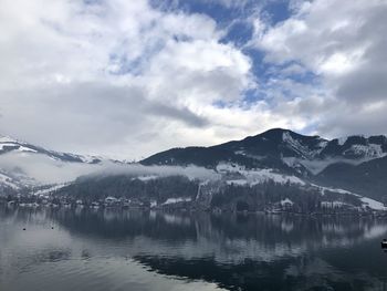 Scenic view of lake and snowcapped mountains against sky