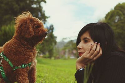 Woman looking at dog on land 