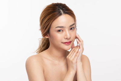 Portrait of young woman against white background