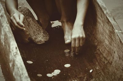 Low section of man stacking coins outdoors