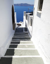 Staircase leading towards sea against sky