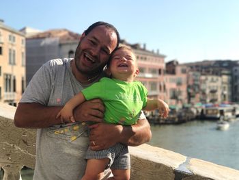 Portrait of man holding son while standing at grand canal