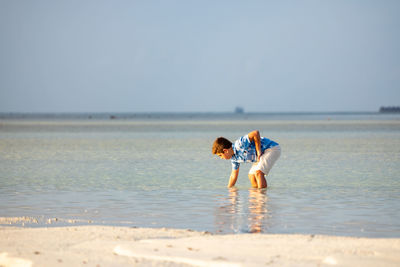 Little kid searching crabs on the beach