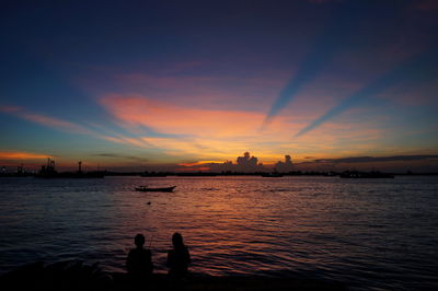 Silhouette pier over sea against sky during sunset