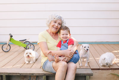 Grandmother sitting with grandson boy on porch at home backyard. bonding of relatives and generation 