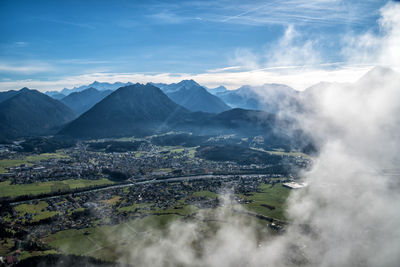 Aerial view of land and mountains against sky