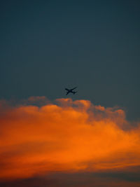 Low angle view of silhouette airplane against sky during sunset