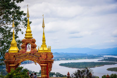 Temple by building against sky