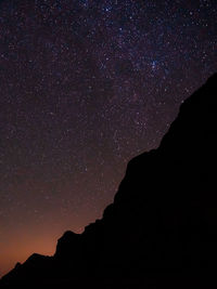 Low angle view of silhouette trees against sky at night