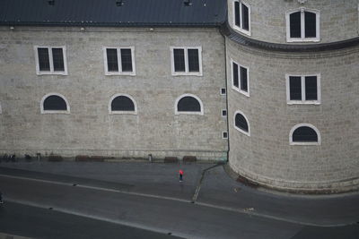 Man walking on road by building