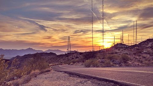 Road by mountain against sky during sunset