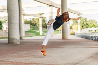 Acrobat practicing jump while exercising at park