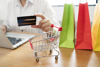 Midsection of man using mobile phone at store