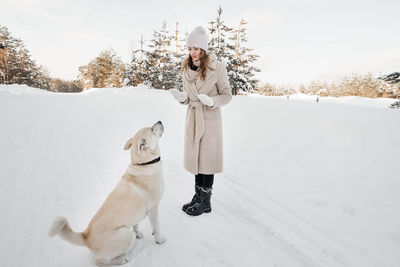 Girl trains a dog in winter