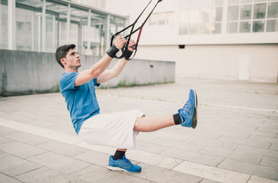 Young man exercising on building terrace