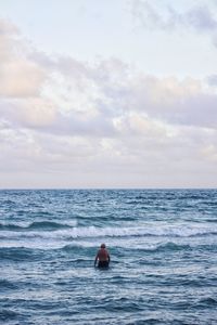 Man swimming in sea against sky