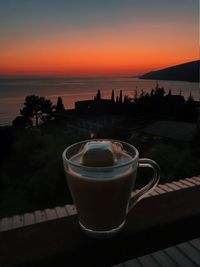 Coffee on table against sky during sunset