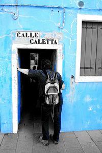 Full length of man standing against blue door