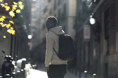 Rear view of woman standing on street at night