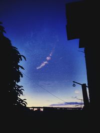 Low angle view of silhouette trees against sky at night