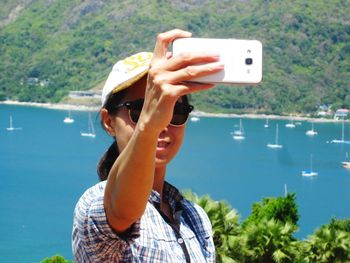 Woman taking selfie against sea