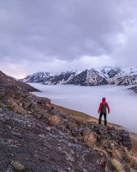 Rear view of man on mountain against sky