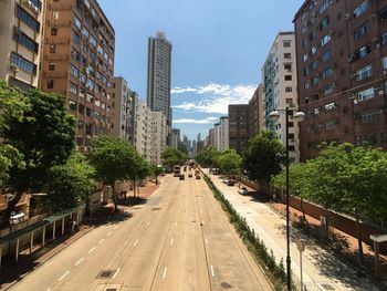 Road amidst buildings in city against sky