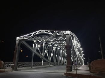 Illuminated bridge against sky at night