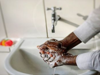 Cropped hands of person washing hand, protection from diseases, cleanliness, bacteria and germs kill