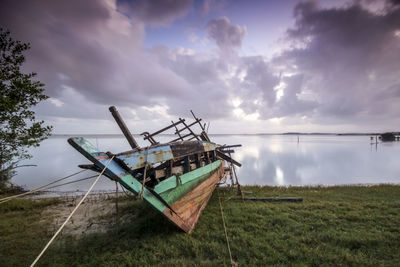 Abandoned ship in water against sky