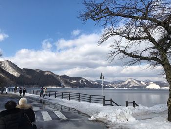 Scenic view of lake by snowcapped mountains against sky