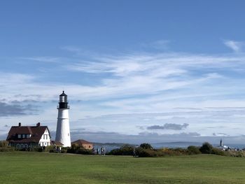 Lighthouse by sea against sky