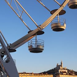 Low angle view of ferris wheel against clear blue sky