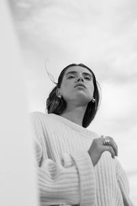 Portrait of young woman against sky